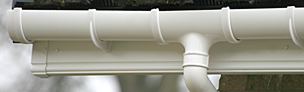 Guttering and downpipe in white fixed to fascia board
